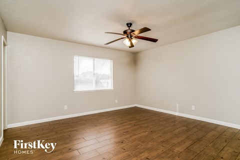 the living room with wood floors and a ceiling fan