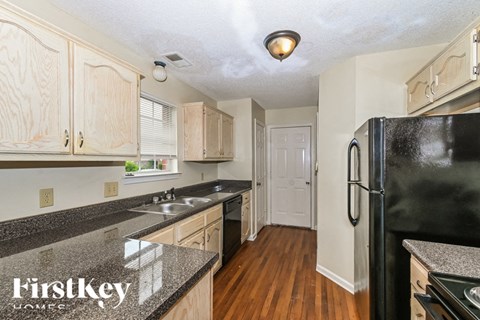 A kitchen with wooden cabinets and black appliances.