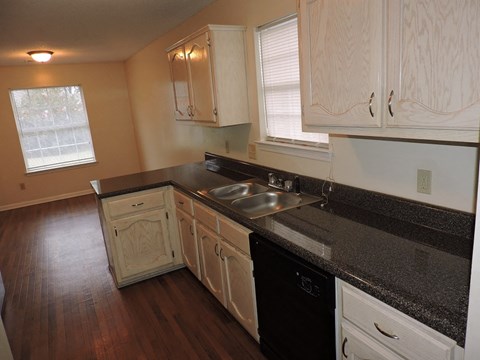 A kitchen with black countertops and white cabinets.