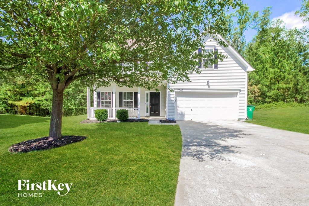 a white house with a tree in front of it