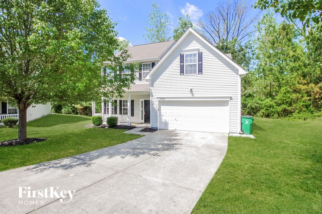 a white house with a driveway in front of it