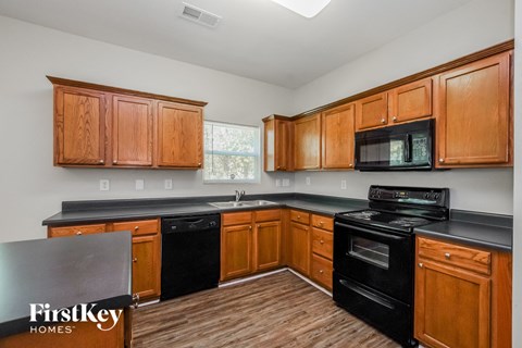 a kitchen with black appliances and wooden cabinets