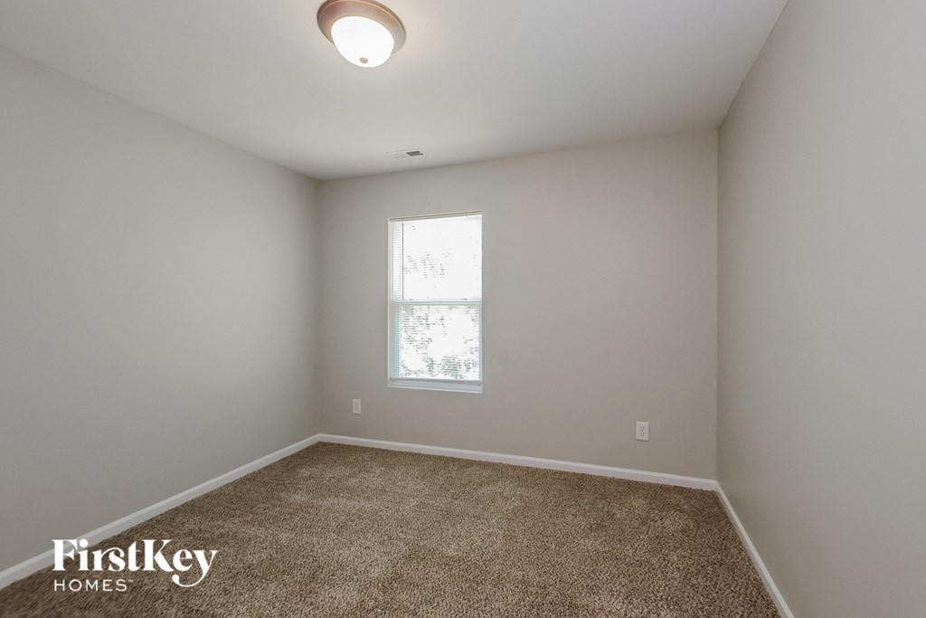 an empty room with carpet and a window