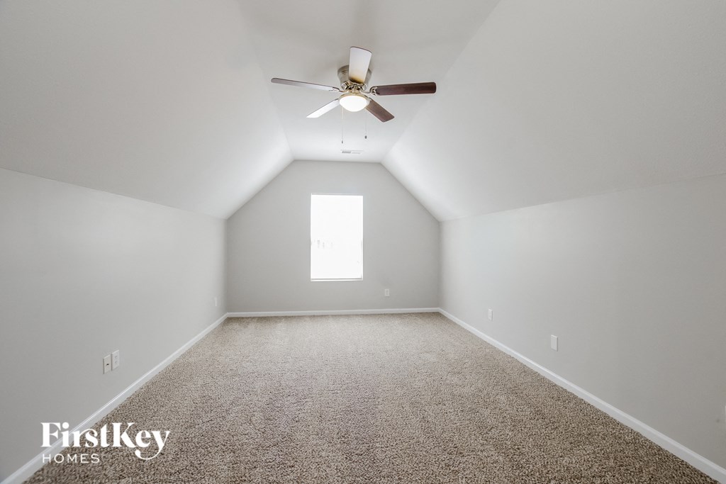 a bedroom with white carpet and a ceiling fan