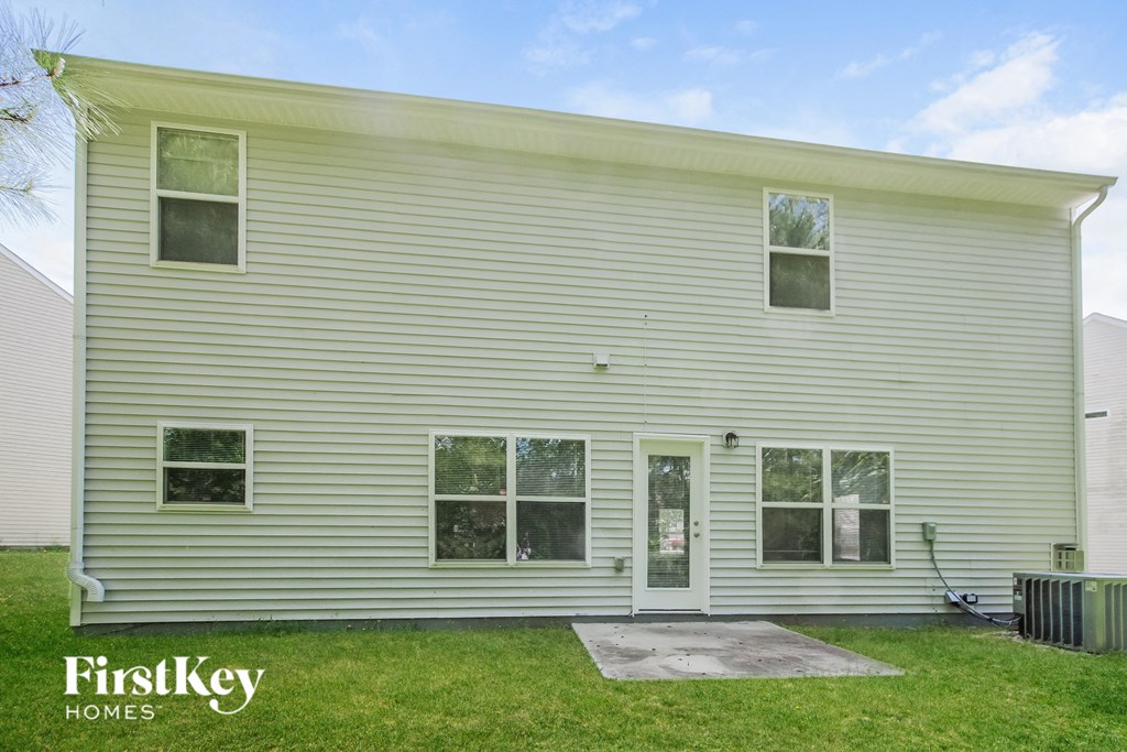 the front of a white house with a yard and grass