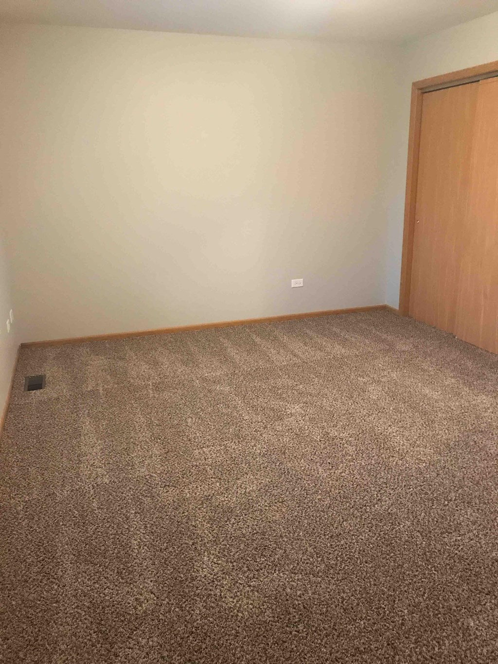 an empty room with carpet and a door