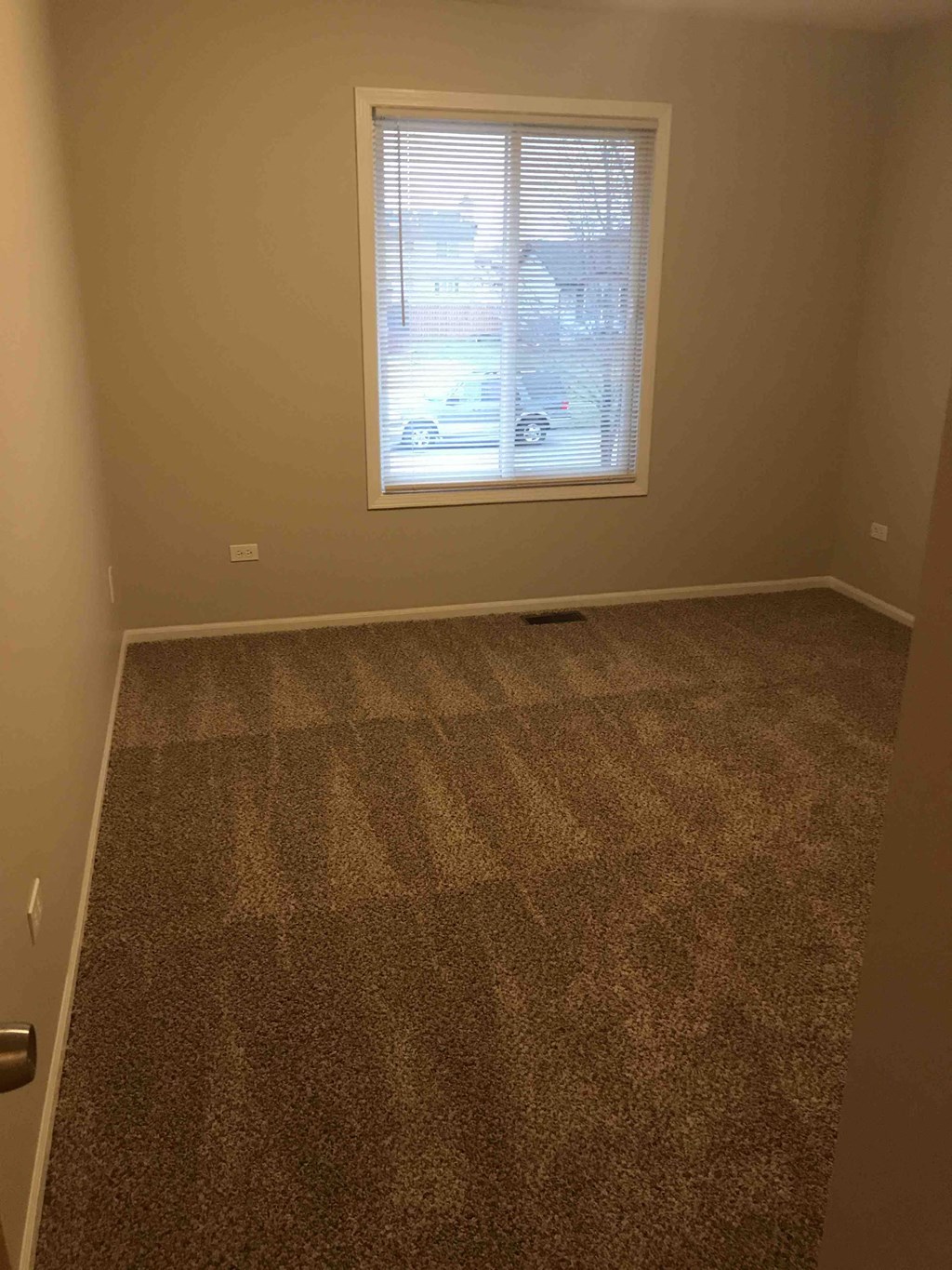a room with a carpeted floor and a window
