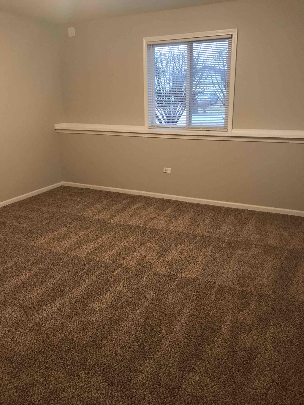 a room with a carpeted floor and a window