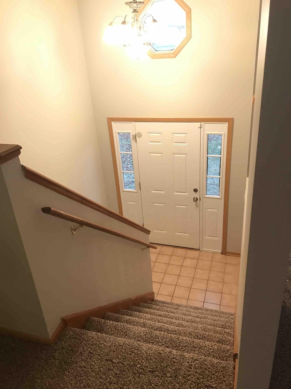 a stairway with a carpeted landing and a white door