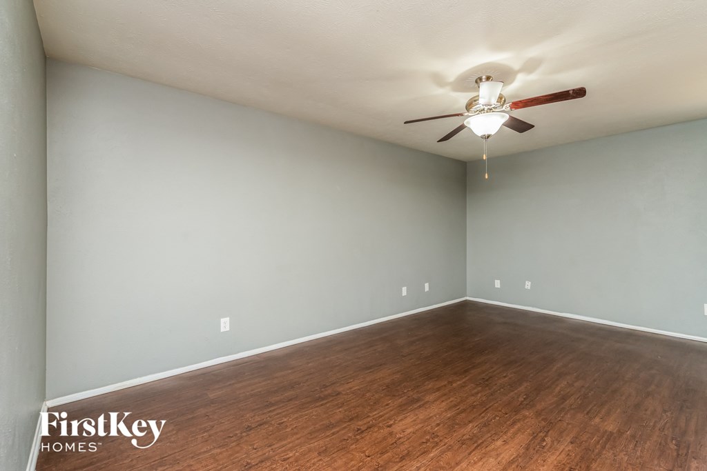 a bedroom with wood flooring and a ceiling fan