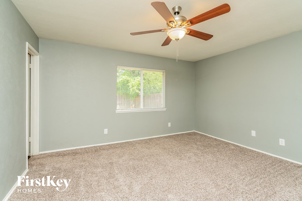 the master bedroom has a carpeted floor and a ceiling fan