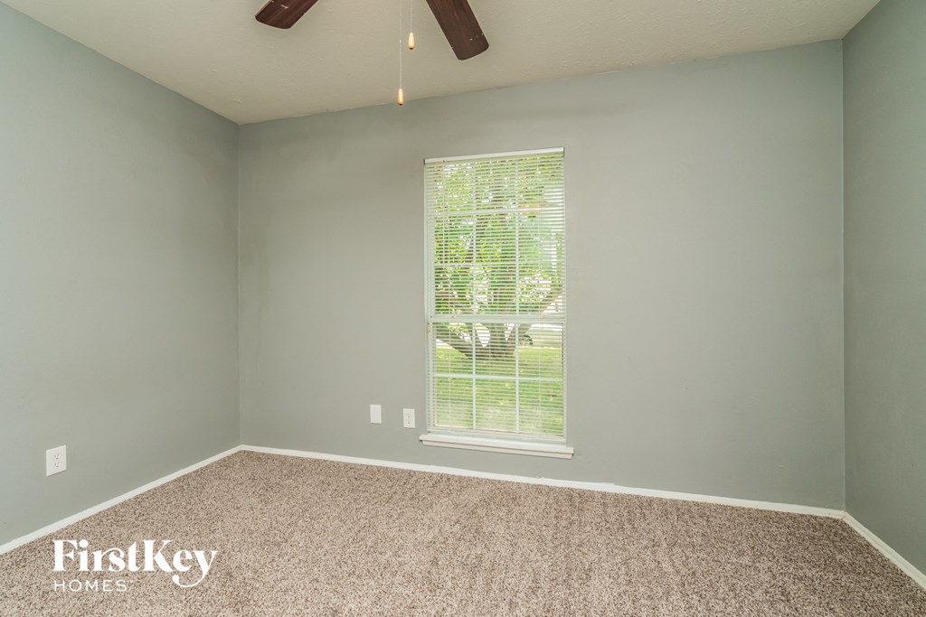 the bedroom with carpet and a window