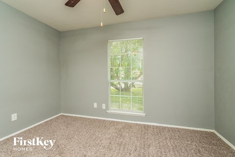 the bedroom with carpet and a window