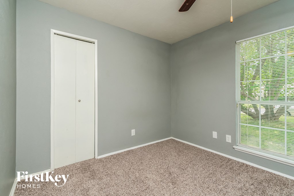 a bedroom with gray walls and a window and a door