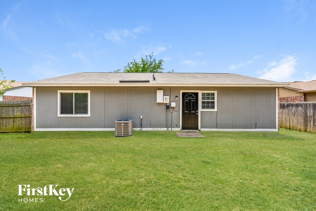 the front of a gray house with a grassy yard