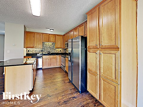A kitchen with wooden cabinets and a stainless steel refrigerator.