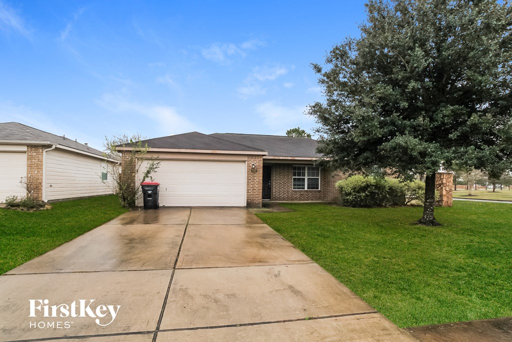 an empty driveway in front of a brick house