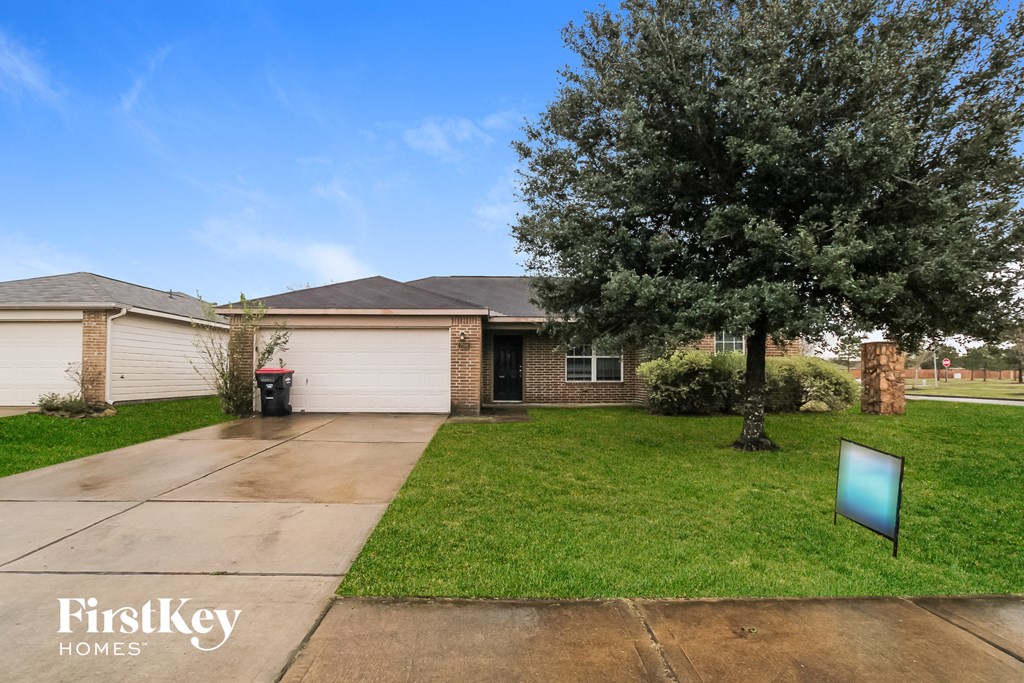 a home with a lawn and a tree in front of it