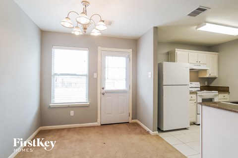 a kitchen with a white refrigerator and a door and a window