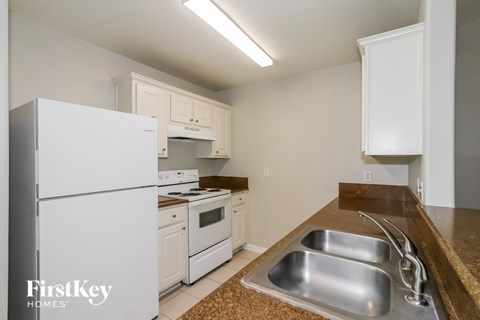 A kitchen with a white fridge and a brown counter top.