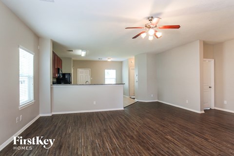 A spacious room with a ceiling fan and wooden flooring.