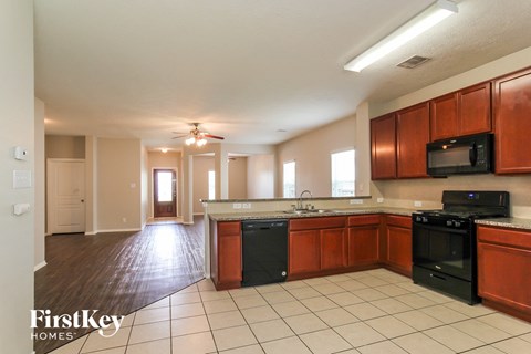 A kitchen with wooden cabinets and black appliances.