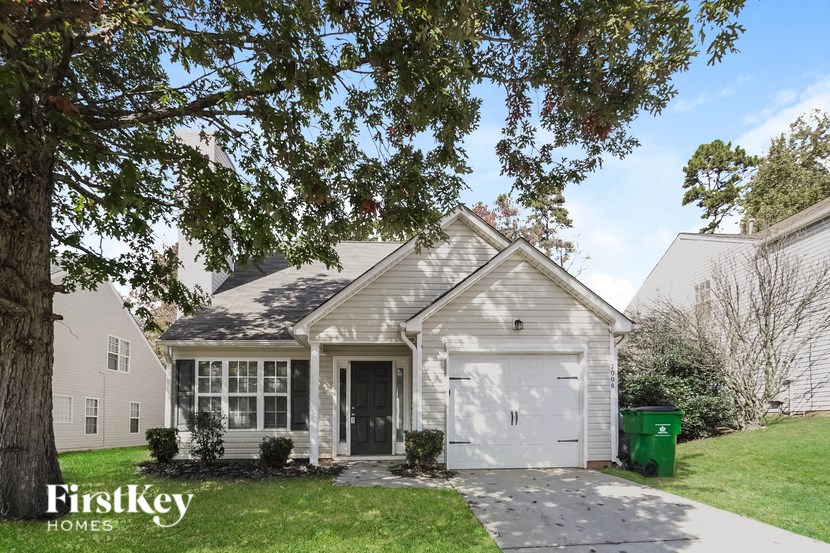 the front of a white house with a white garage door