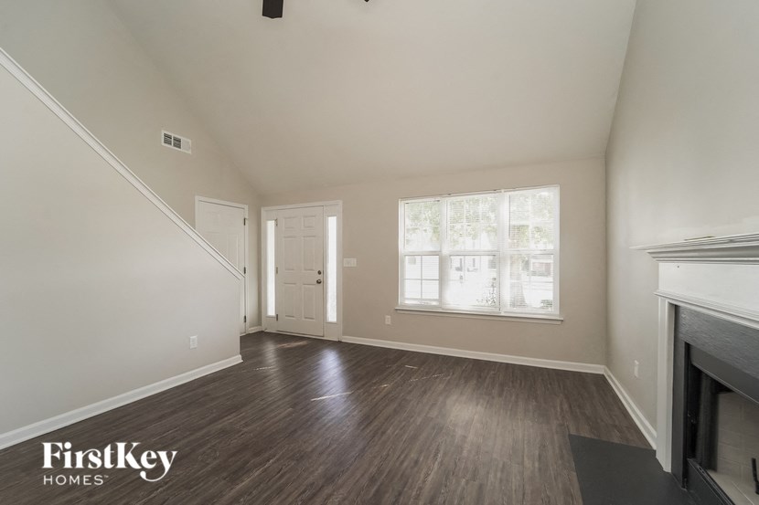 an empty living room with wood floors and a fireplace