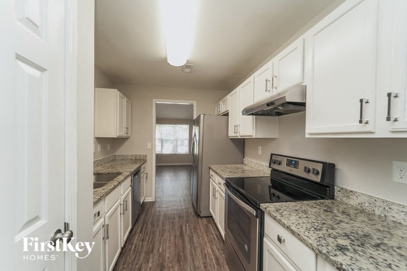 a kitchen with white cabinets and a black stove