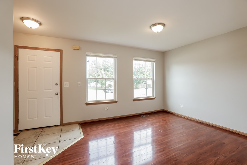 A room with wooden floors and two windows.