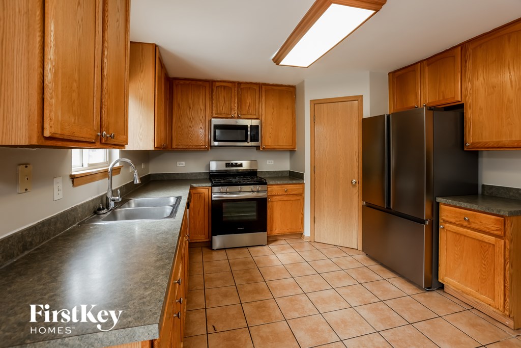 A kitchen with wooden cabinets and black appliances.