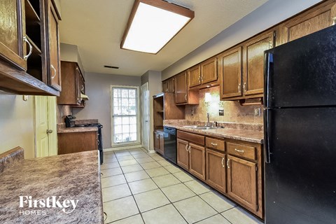 a kitchen with wooden cabinets and a black refrigerator