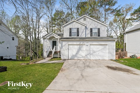 a white house with a garage and a driveway