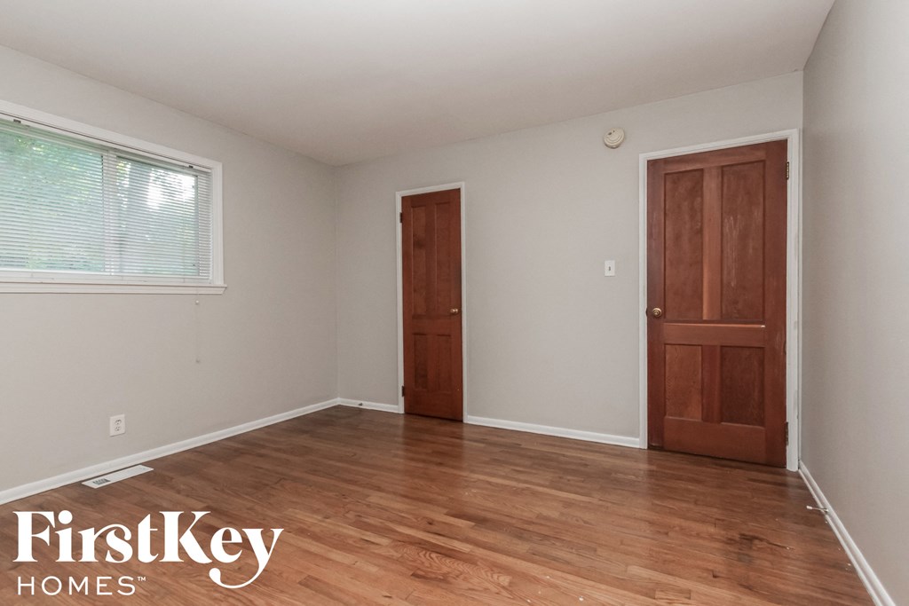 a room with wood floors and a door and a window