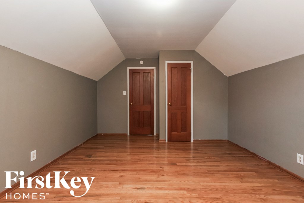 a empty room with wooden floors and two doors