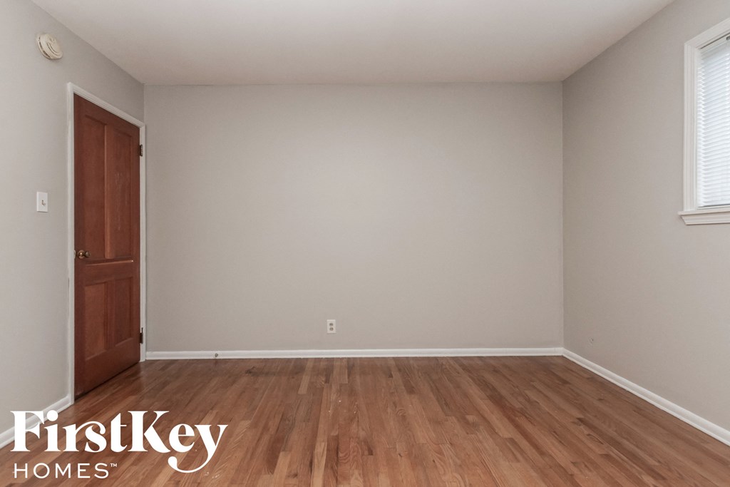 a bedroom with wooden floors and a wooden door