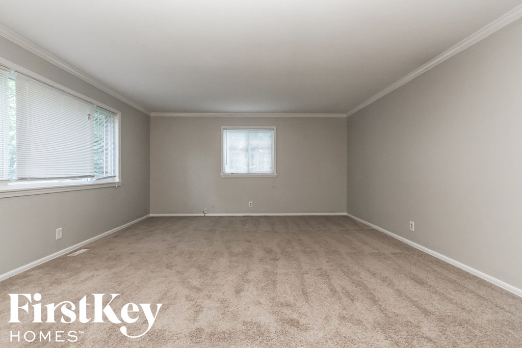 a empty room with carpet and a window