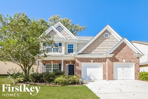 A house with a brick facade and a white garage door is for sale.