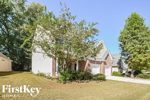 A house with a white garage door is for sale by FirstKey Homes.