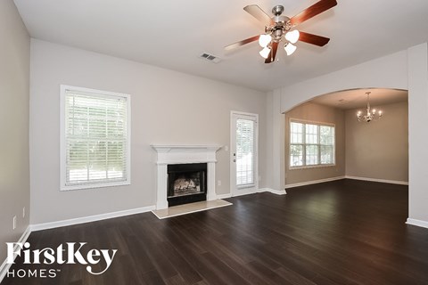 A spacious room with a fireplace and a ceiling fan.