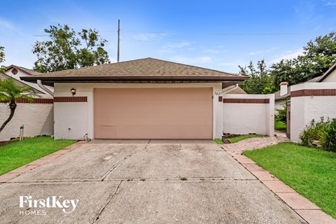 a white house with a garage door and a driveway