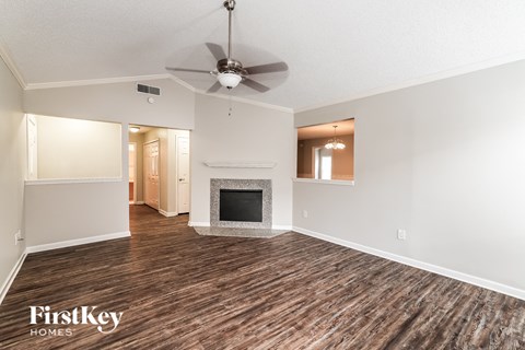 a living room with a fireplace and a ceiling fan