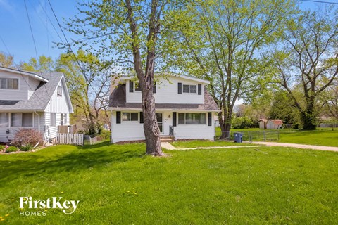 a white house with a yard and a tree