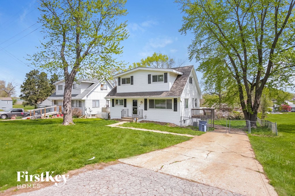 a white house with a sidewalk in front of it