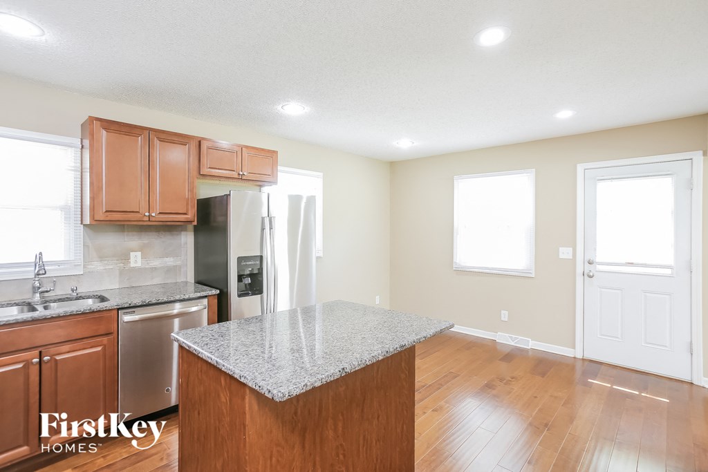 a kitchen with wood floors and a granite counter top