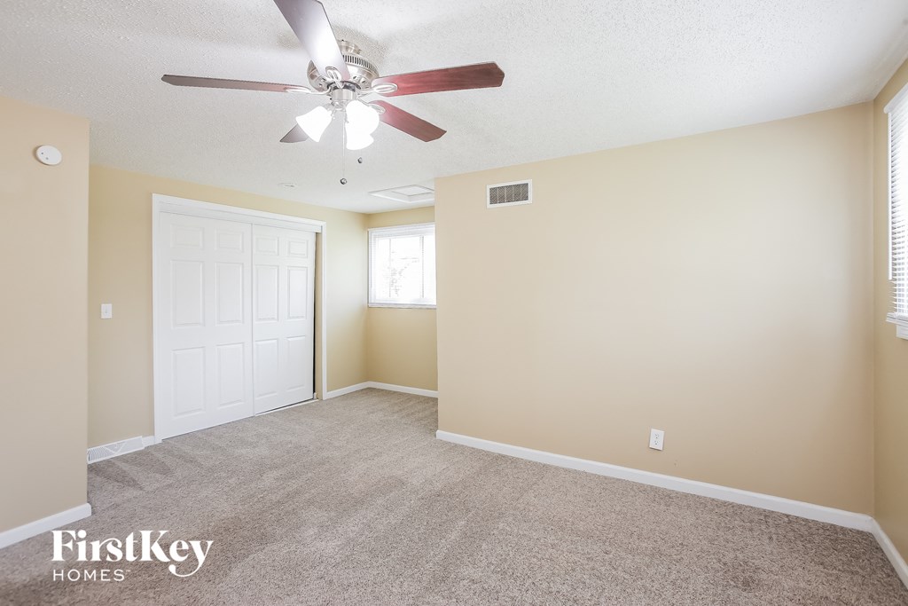 the living room of an empty house with a ceiling fan
