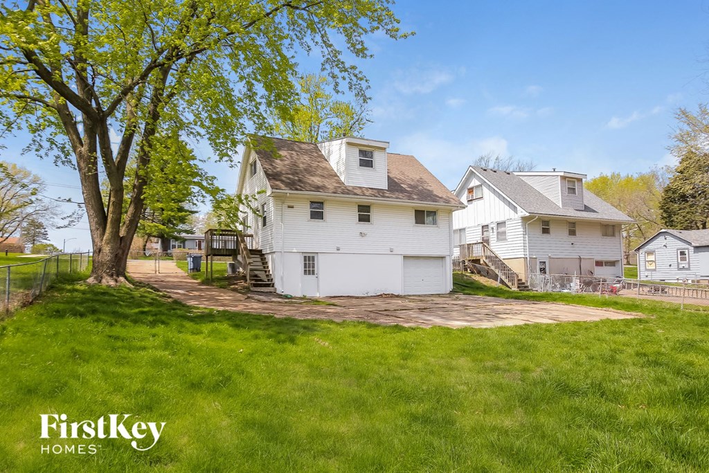 a white house with a yard and a tree