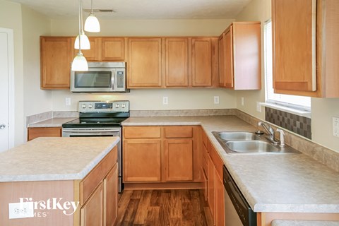A kitchen with wooden cabinets and a granite countertop.
