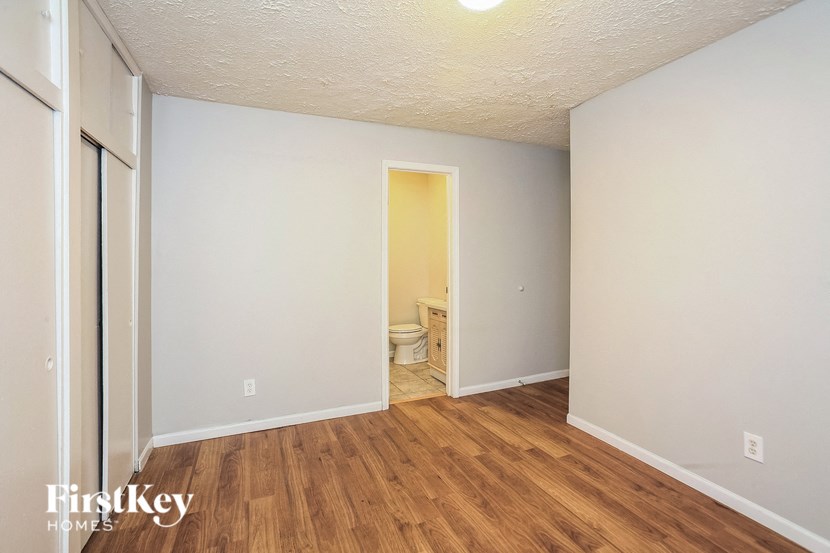 the living room of an apartment with wood flooring and a toilet