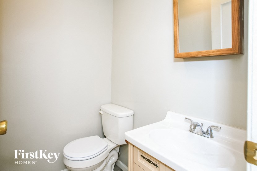 a bathroom with a sink toilet and a mirror